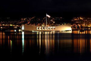 Night time image of the USS Arizona Memorial.  Pearl Harbor tours are available to see this historic site.